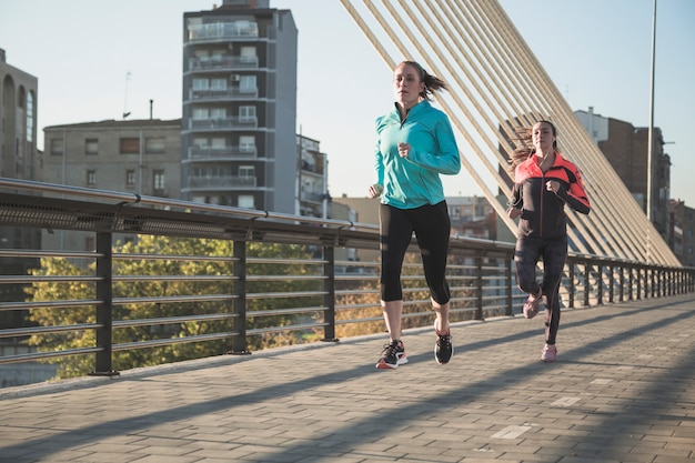 Free photo young women running with city background