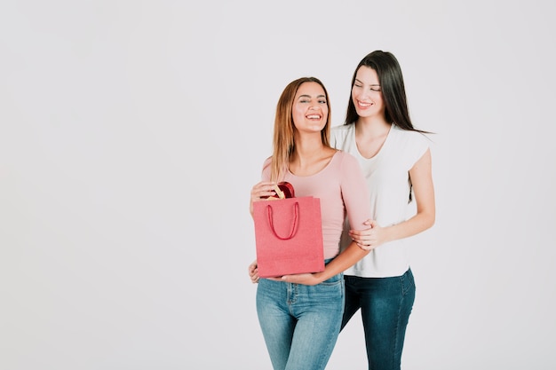 Young women standing with paper bag
