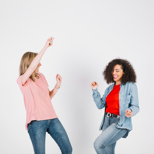 Young women in stylish outfits dancing