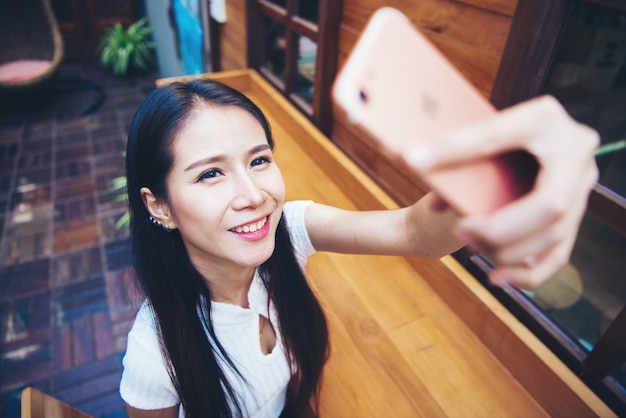 Молодые женщины берут селфи из рук со смартфоном