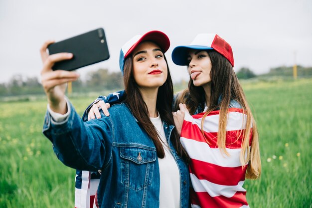 Young women taking photo on phone outside