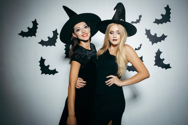 Free photo young women wearing witch hats on halloween