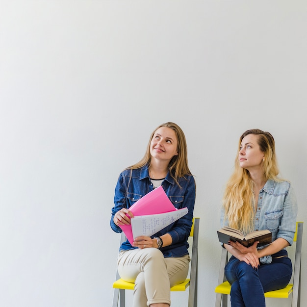 Young women with books listening