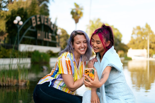 Young women with dyed hair near lake