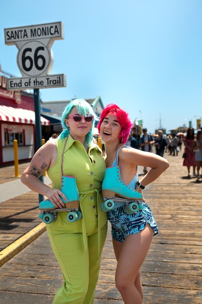 Young women with dyed hair near seaside