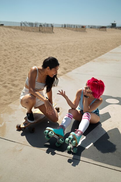 Free photo young women with dyed hair near seaside