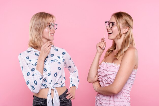 お互いを見てメガネマスクを持つ若い女性 無料の写真