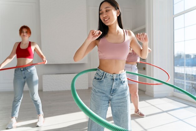 Free photo young women with hula hoops