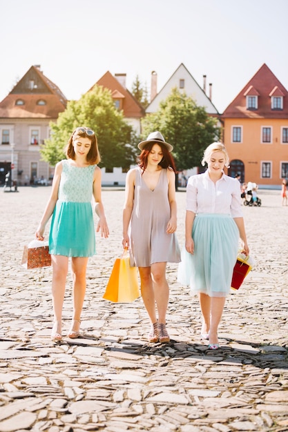 Young women with shopping bags on street