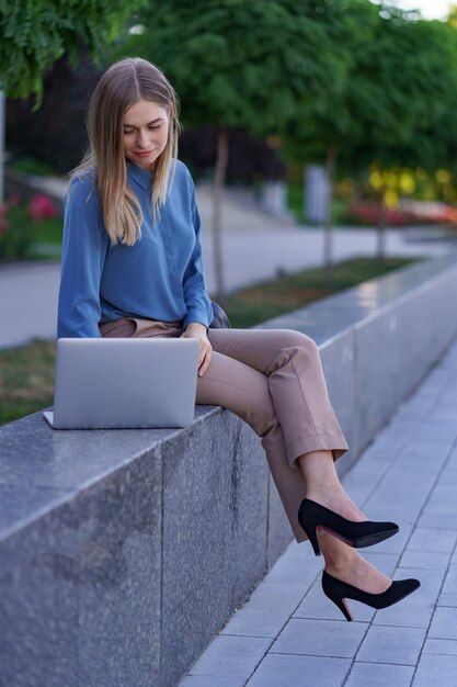 도시 광장에 노트북에서 일하는 젊은 여성