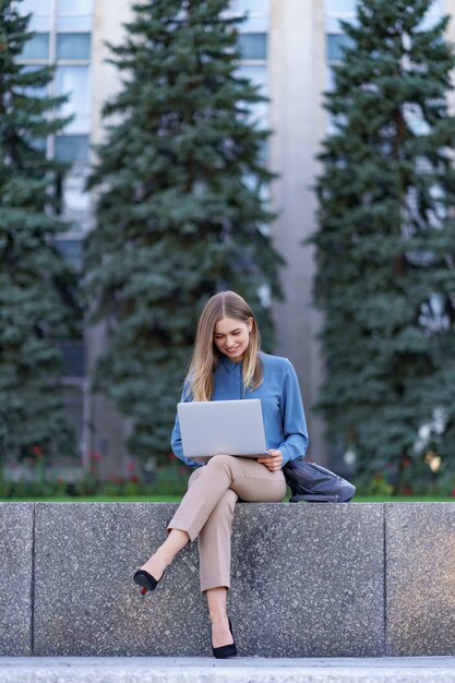 Молодые женщины, работающие на ноутбуке на городской площади