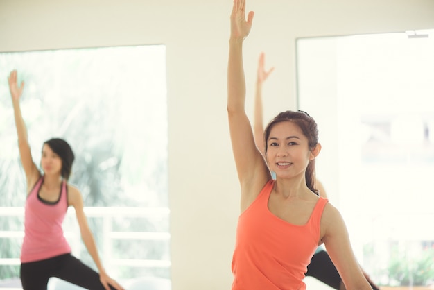 Young women yoga indoors keep calm and meditates while practicing yoga to explore the Inner Peace. Yoga and meditation have good benefits for health. Photo concept for Yoga Sport and Healthy lifestyle