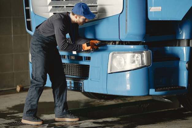 若い労働者が車輪をチェックします。トラックの故障。サービス作業。