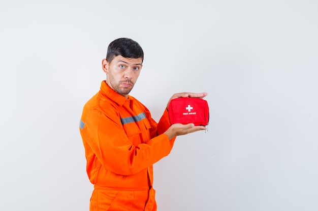 Young worker holding first aid kit in uniform.