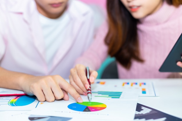 Free photo young worker's hands pointing on paper graphs