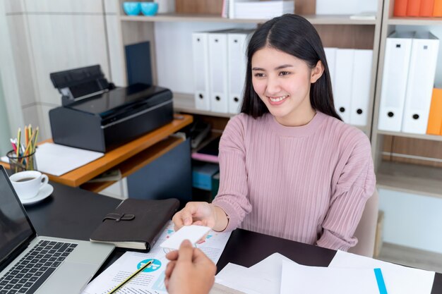 Young working woman recieve namecard from businessman