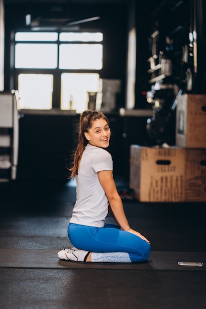 Young yoga woman kneeling on the floor.