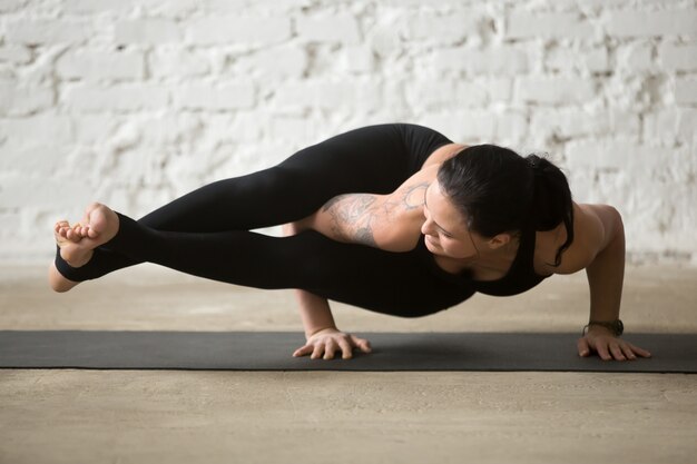 Astavakrasana 포즈, 화이트 로프트 바에서 젊은 요기 매력적인 여자