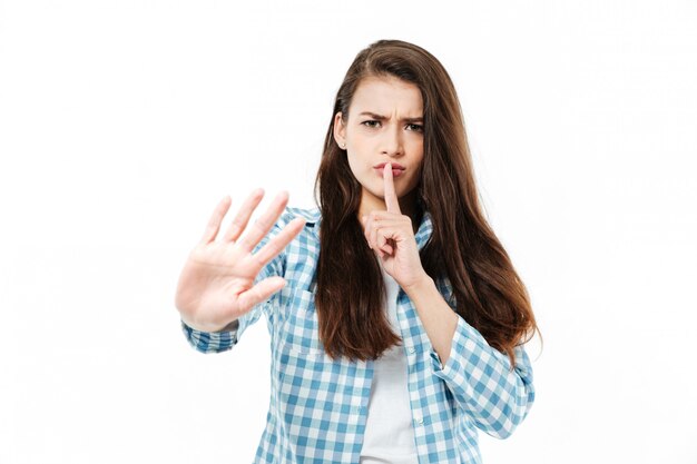 Young young woman showing silence gesture isolated