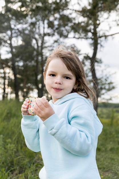 Free photo youngster outdoors eating a dessert