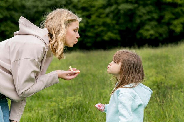 Youngster outdoors and mom blowing kisses