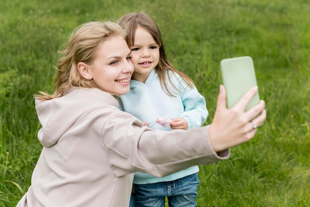 屋外の若者とお母さん、selfieを取る