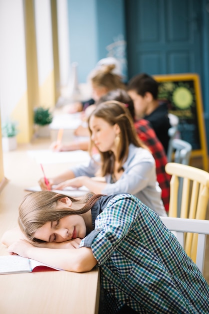 Free photo youngster sleeping in classroom