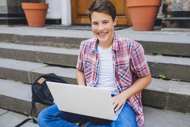 Youngster with laptop on stairs