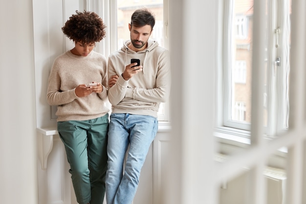 Youngsters of different races use modern gadgets for surfing internet, ignore real communication