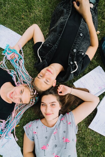 Youngsters on green grass with books