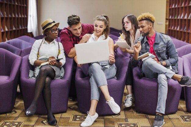 Youngsters watching laptop in library