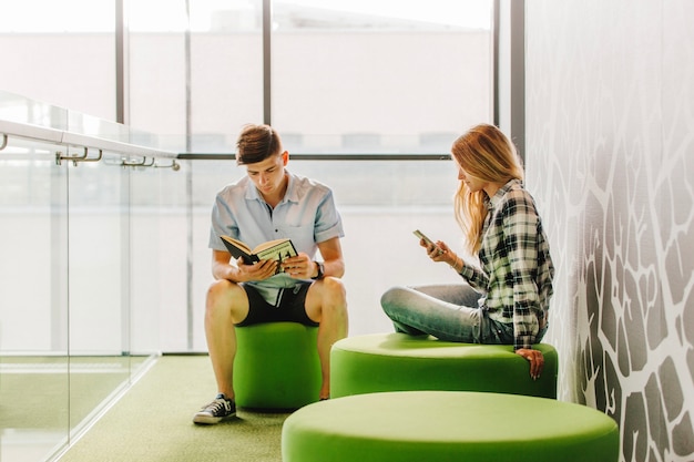 Foto gratuita giovani con libro e telefono