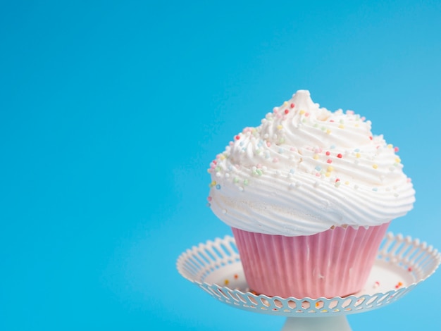 Yummy birthday muffin on blue background