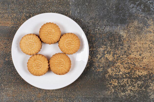 Foto gratuita biscotti squisiti riempiti di crema sulla zolla bianca.