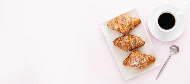 Deliziosi croissant con caffè e cucchiaio