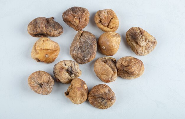 Yummy dried figs on white table.