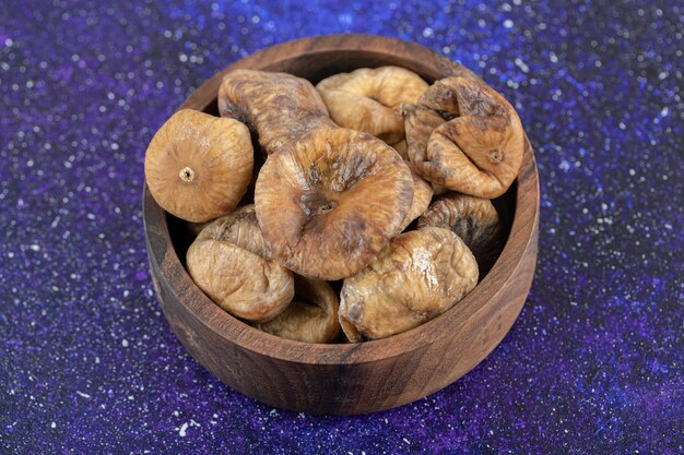 Yummy dry figs in wooden bowl.