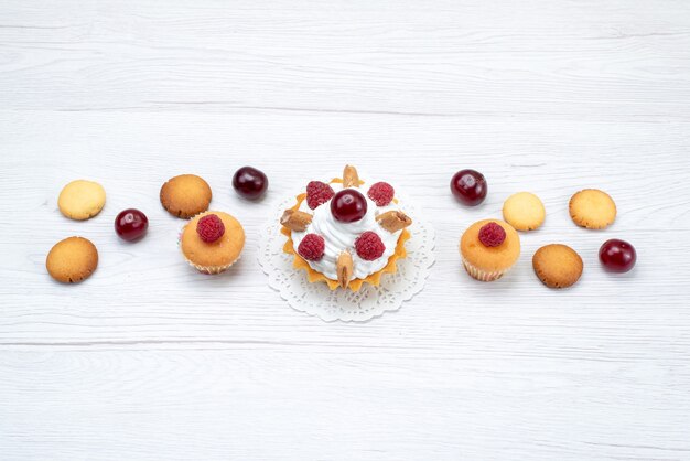 yummy little cakes with raspberries along with cookies on light