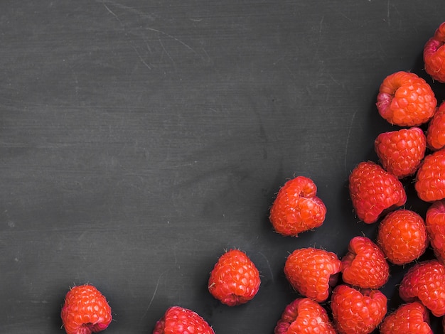 Yummy raspberries on dark surface