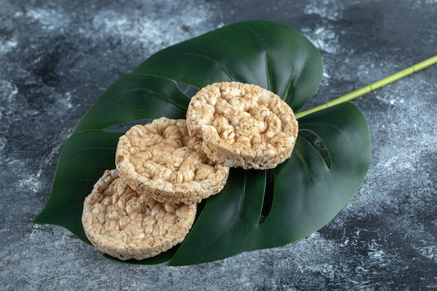 Yummy round crispbread on green leaves.