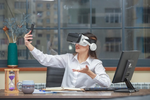 YYoung geek girl wearing VR glasses and taking selfie