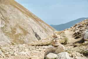 Free photo zen balanced stones stacked in a pyramid on a pass in the high mountains against the sky hiking