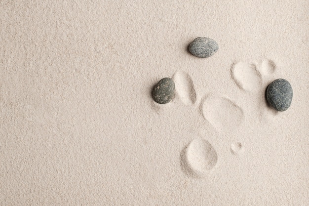 Free photo zen stones sand background health and wellness concept