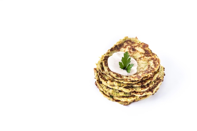 Zucchini fritters with yogurt sauce isolated on white background Vegetable pancakes