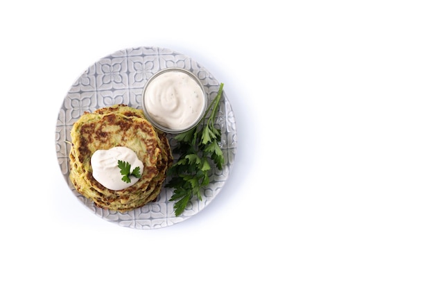 Zucchini fritters with yogurt sauce isolated on white background