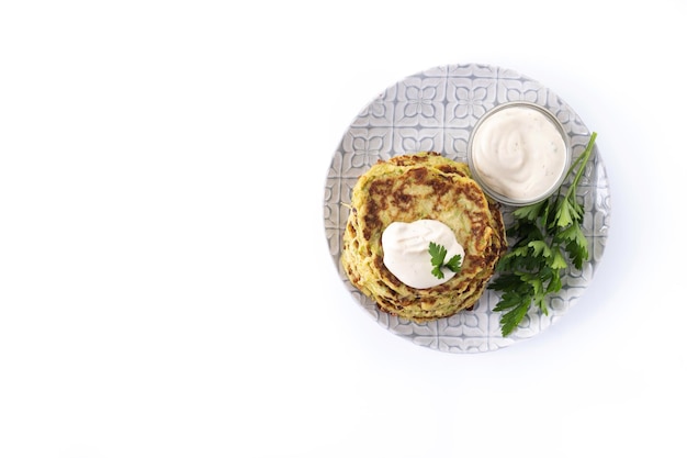 Zucchini fritters with yogurt sauce isolated on white background