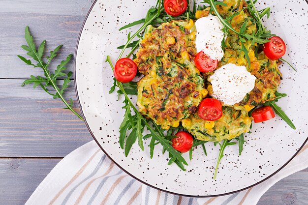 Zucchini pancakes with corn and sour cream