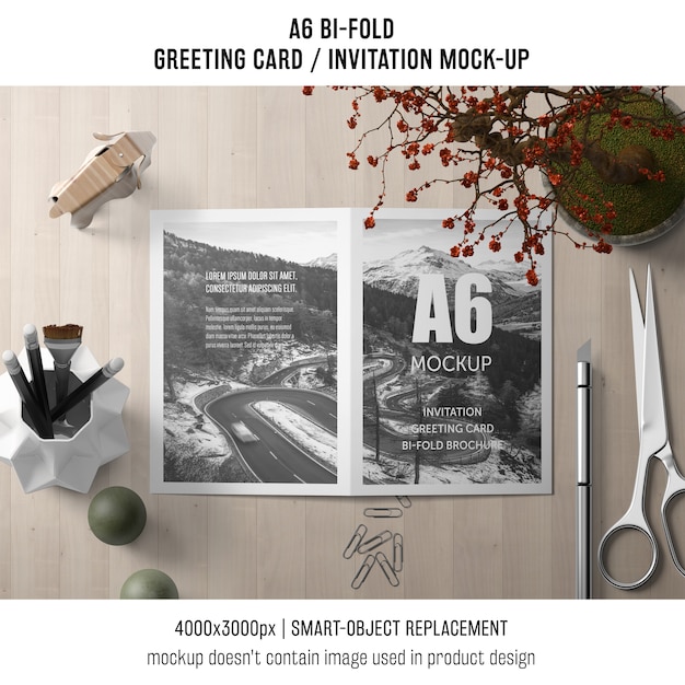 Free PSD a6 bi-fold invitation card template with scissors and plant