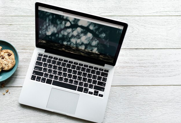 Aerial view of computer laptop and cookies on wooden table