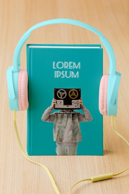 Arrangement with book cover mock-up and headphones